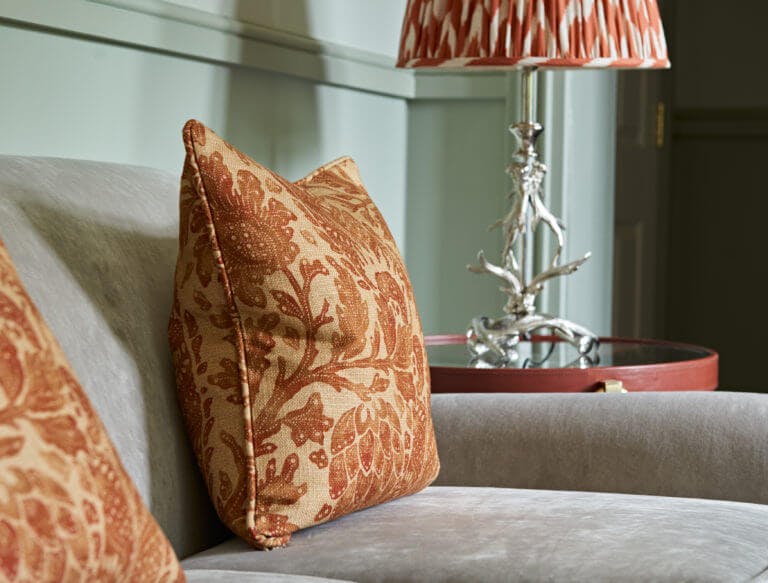 Close up shot of sofa with orange cushion detail in hotel room