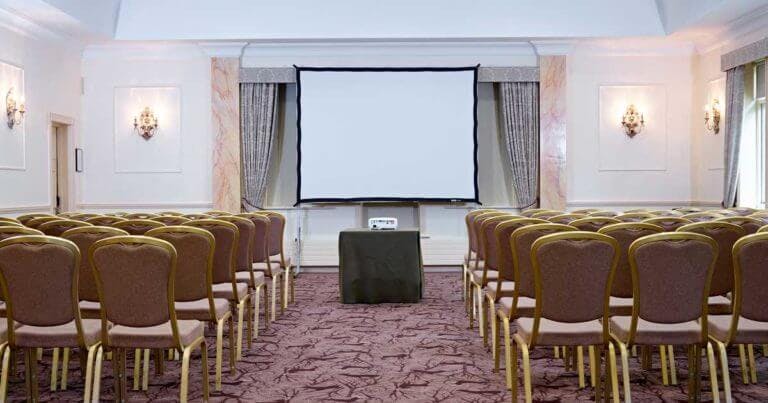 Room set up for a conference with large projector screen