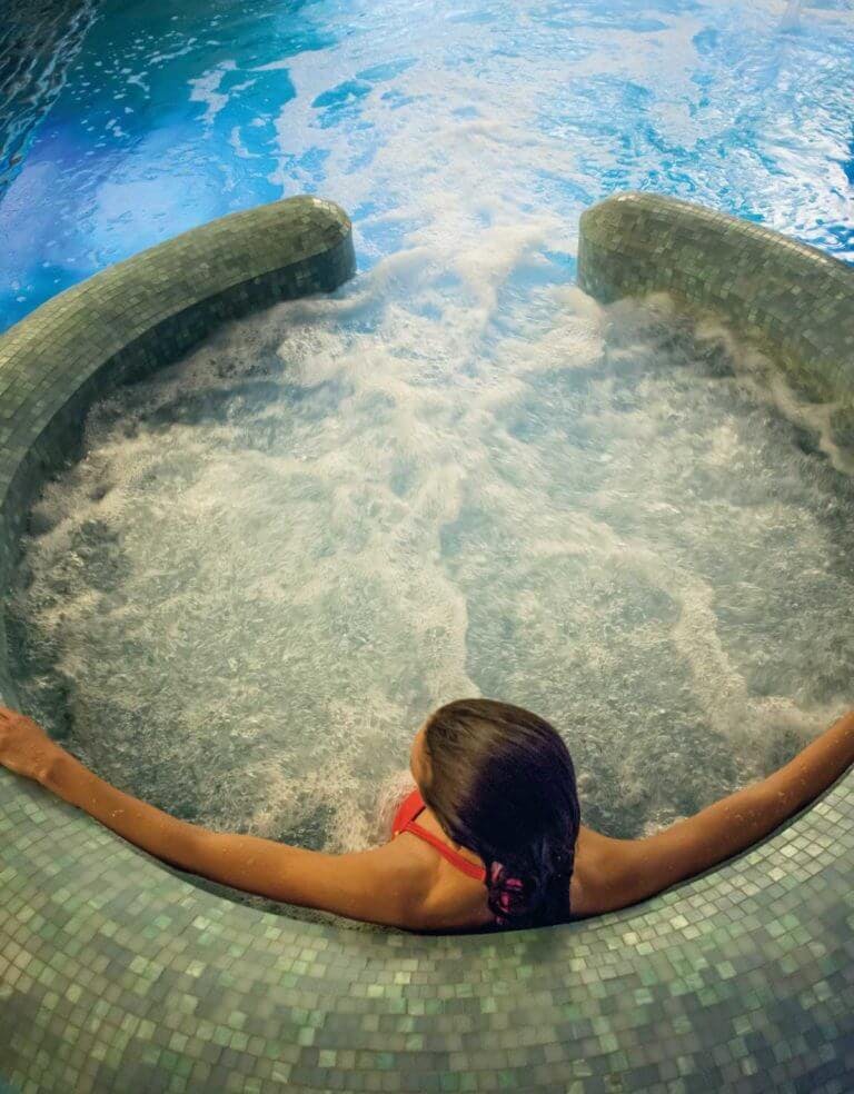 Woman relaxes in bubbling Jacuzzi in hydrotherapy pool at SenSpa