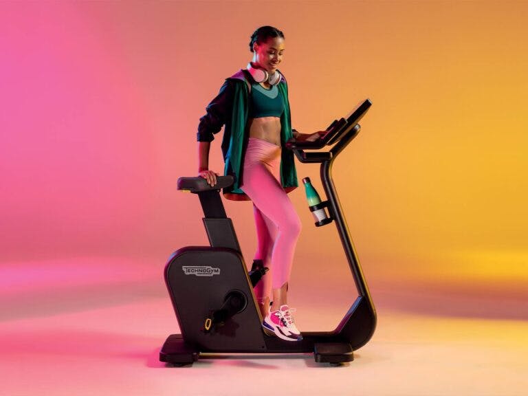 Woman working out using Technogym equipment - colourful background