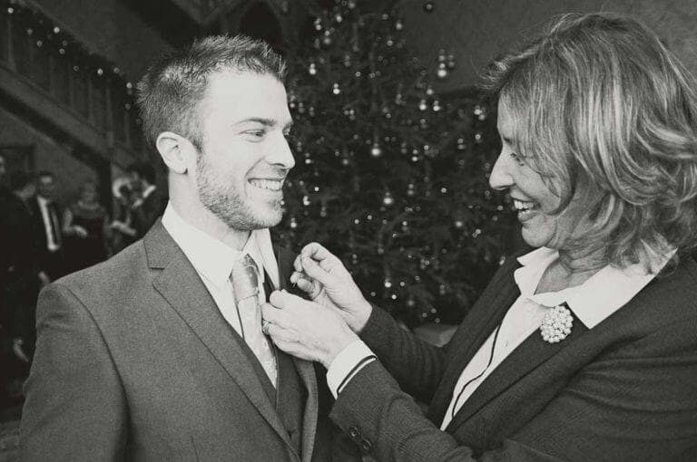 Wedding Coordinator pinning the button hole on a groom at Careys Manor Hotel & SenSpa