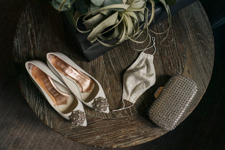 Wedding shoes, mask and glittery bag with a wedding bouquet