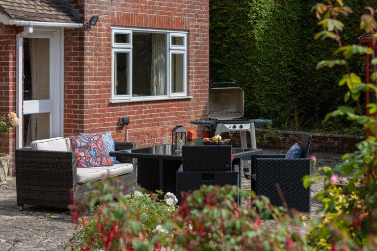 BBQ outside cottage with seating