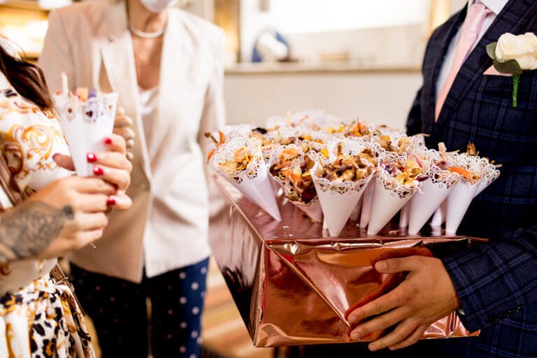 Wedding guests picking up cones of confetti 