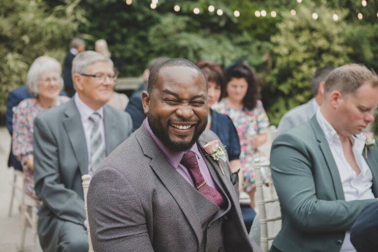 Guests smiling waiting for the bride at Hampshire Wedding venue Careys Manor Hotel