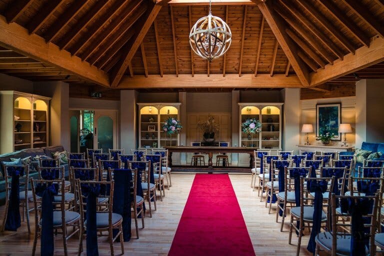 The lounge set for the wedding ceremony with blues sashes on the chairs