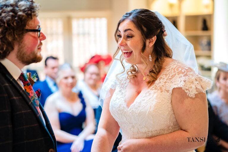 The Bride smiles and laughs during the ceremony with the groom