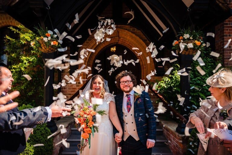 Guests throw confetti over the Bride and Groom as they exit the main entrance