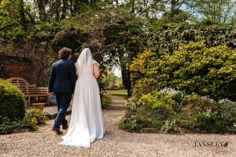 Bride and Groom walking away towards the garden
