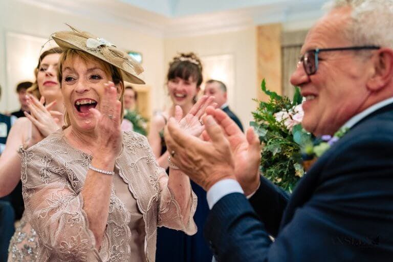 Guests stand and clap in the Bride and Groom to the Wedding Breakfast