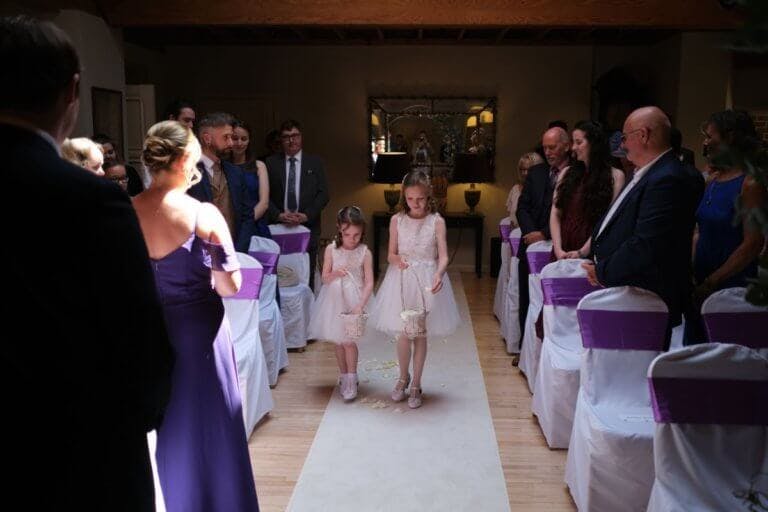 Flower girls through petals down the white carpet