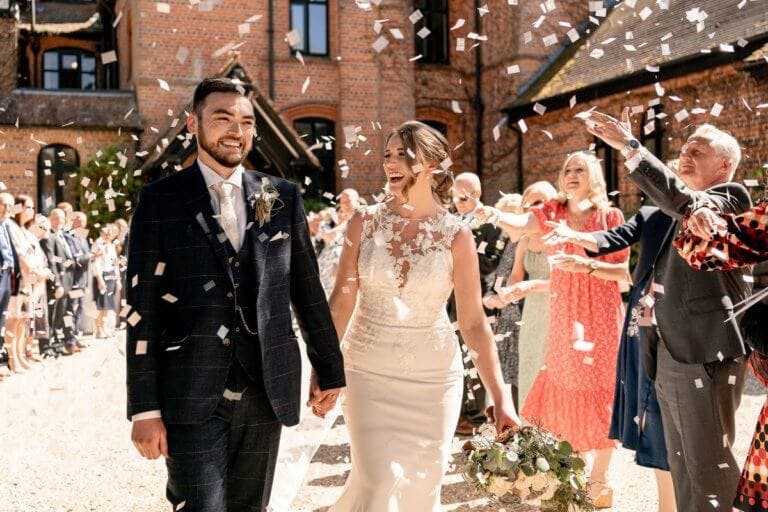 Guests throw confetti over the bride and groom outside the hotels main entrance