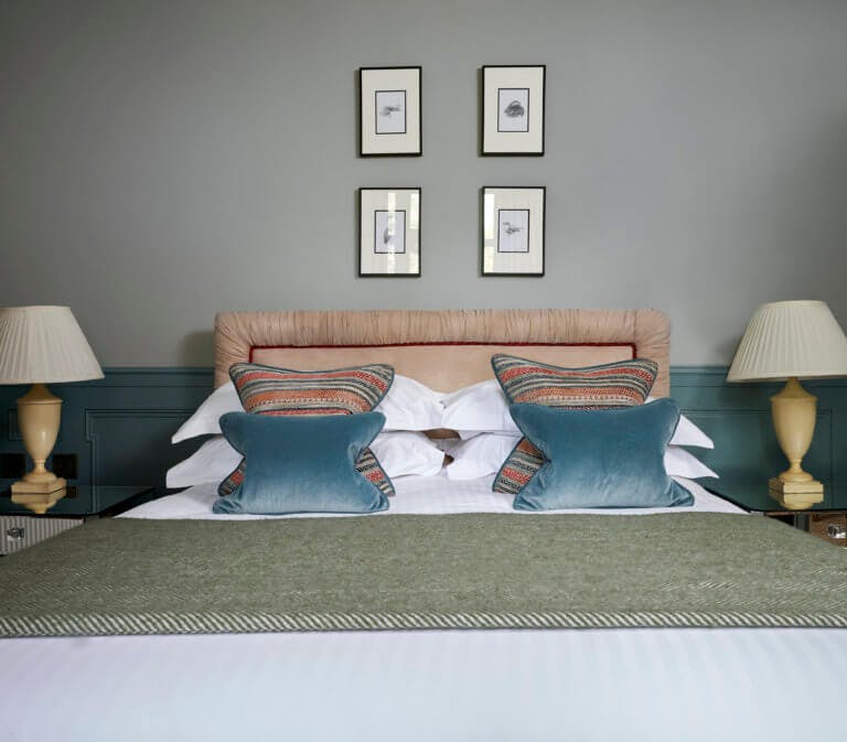 Hotel bedroom with double bed in room with nature artwork on walls