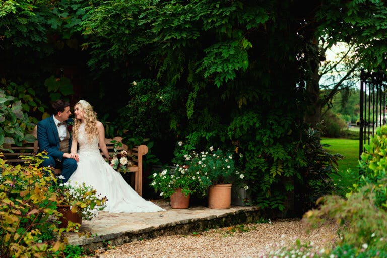 The couple sit on a bench in the garden