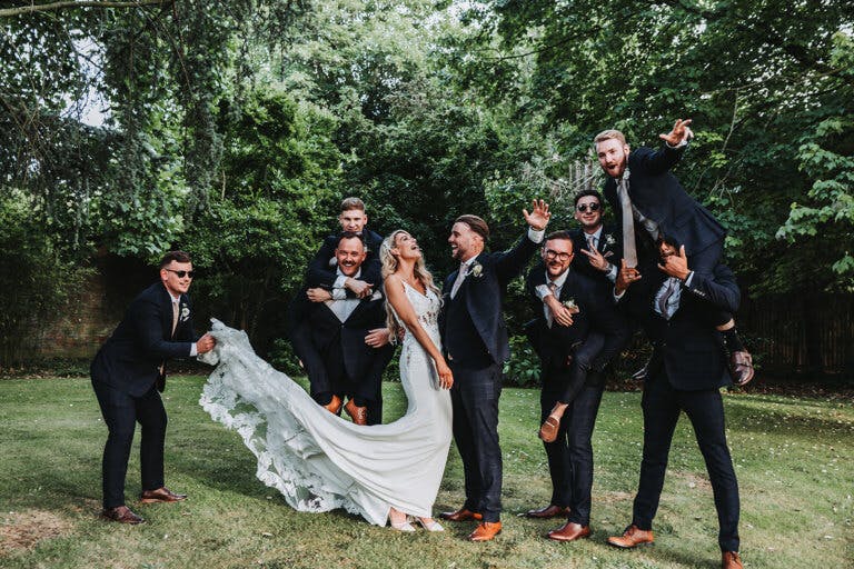 The married couple and the grooms party pose for photos