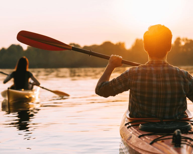 Couple kayaking at sunset on the river