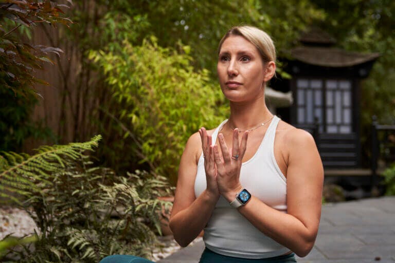SenSpa member practicing meditation in Zen Garden courtyard surrounded by green trees