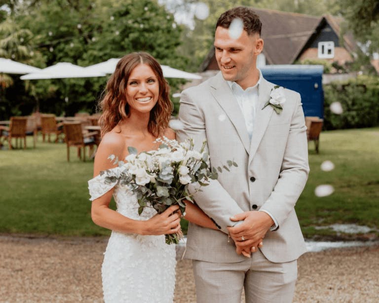 Oliver & Olivia's wedding: Couple in front of neigh bar