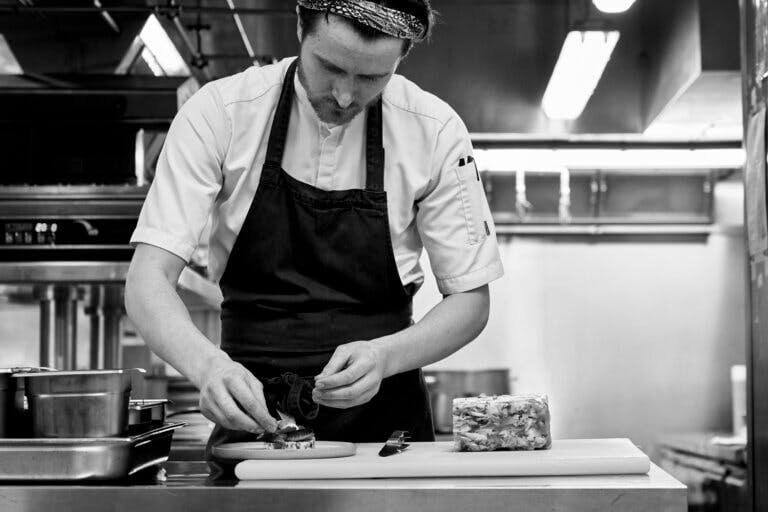 Head Chef Dylan on the pass plating up a dish