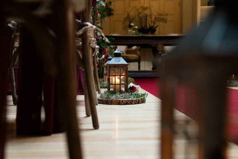 Photo taken from the ground of the chair legs and a close image of the storm lantern with candle at Hampshire wedding venue Careys Manor Hotel & SenSpa.