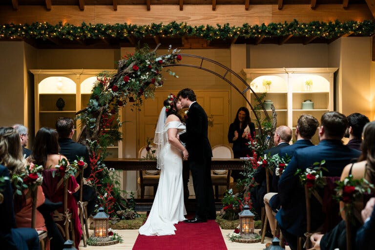 The bride and groom, Maxine & Alastair kiss under the moon gate at the end of their wedding ceremony.