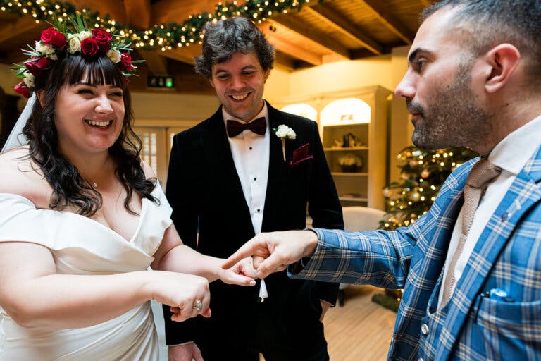 The bride and groom smile with the magician Alfie at Hampshire wedding venue Careys Manor Hotel & SenSpa.