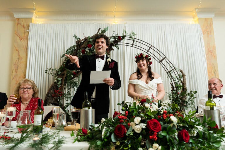 The bride and groom stand at the top table for their wedding speech.