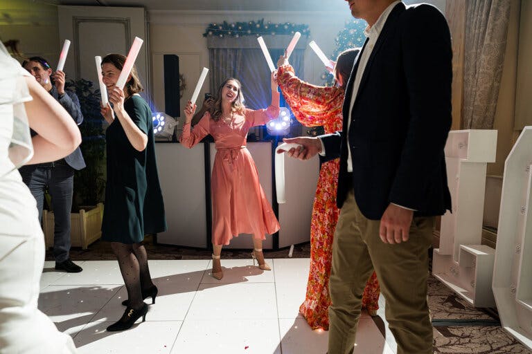 Maxine & Alastair's wedding reception. Guests dance on the dance floor with glow sticks.