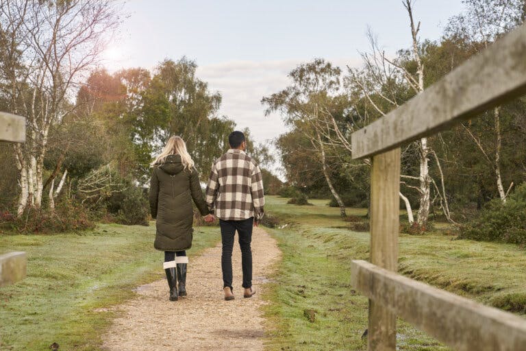 Couple walking hand-in-hand away from the camera in the New Forest | New Forest Hotel Careys Manor Hotel & SenSpa