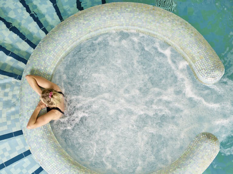 Ariel shot of lady relaxing in the hydrotherapy pool at SenSpa | New Forest Careys Manor Hotel & SenSpa