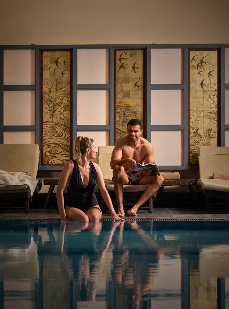 A couple relaxing poolside at a spa