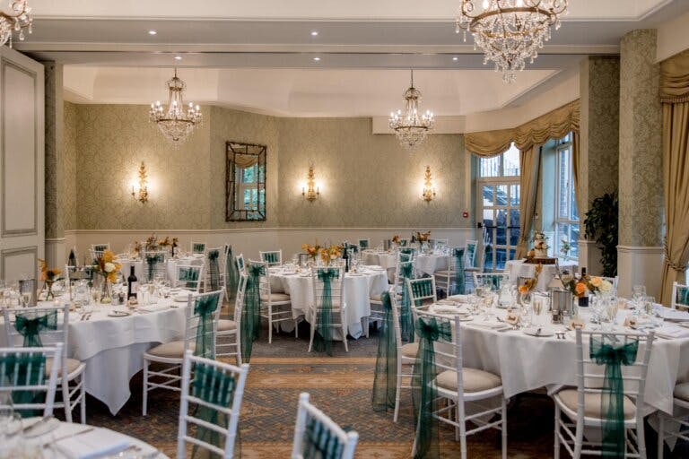 Manor Suite set as a wedding breakfast with a straight top table and round guest tables