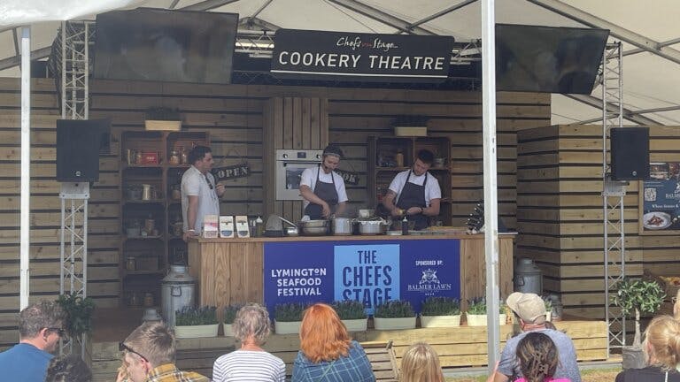 Chefs Dylan and Louis with TV presenter Chris Bavin taking part in a cookery demo on the stage at the Lymington seafood festival.