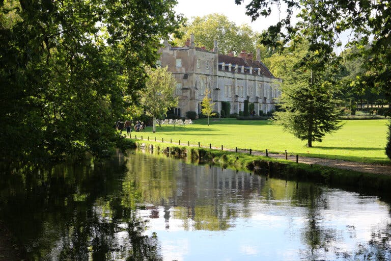 looking across a lake towards Mottisfont House in Spring