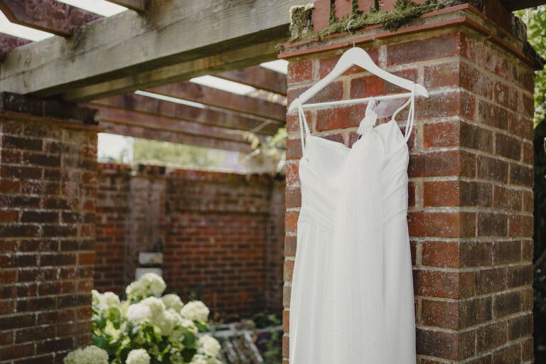Wedding dress hanging in the garden. Close up for the top half of the dress.