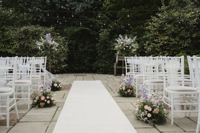 View down the aisle from the registrars table of the white chairs lined ready for the ceremony.