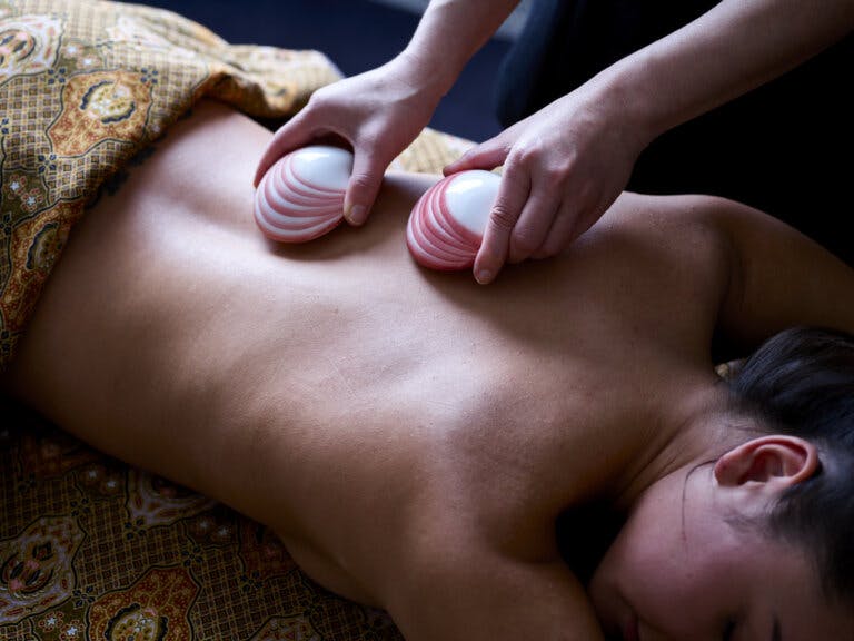 Women receives lava shell massage at Careys Manor Hotel & SenSpa