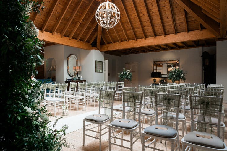 Side view across the lounge with the white wooden chairs set theatre style with a central aisle