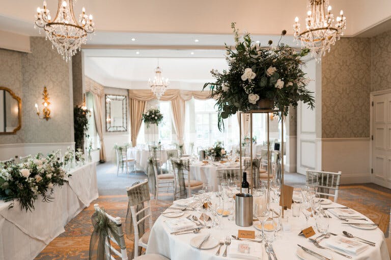 The Manor Suite set for the wedding breakfast with high white floral arrangements