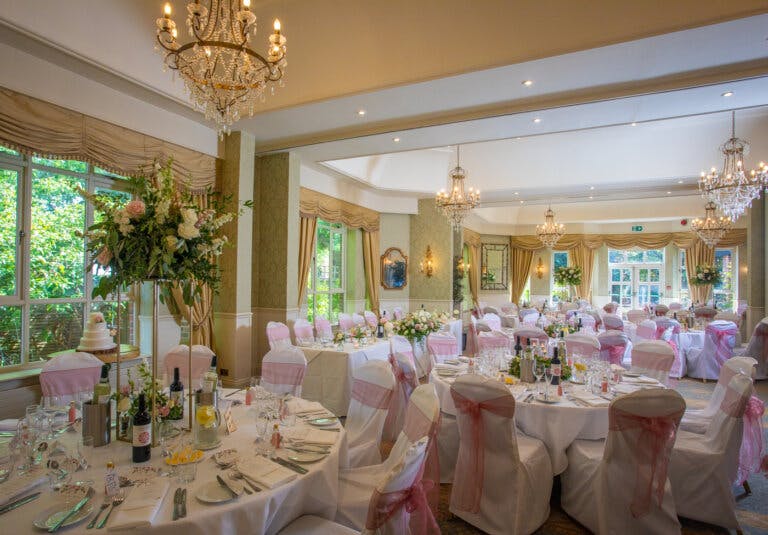 The wedding breakfast room dress with floral arrangements of different heights in pinks and whites