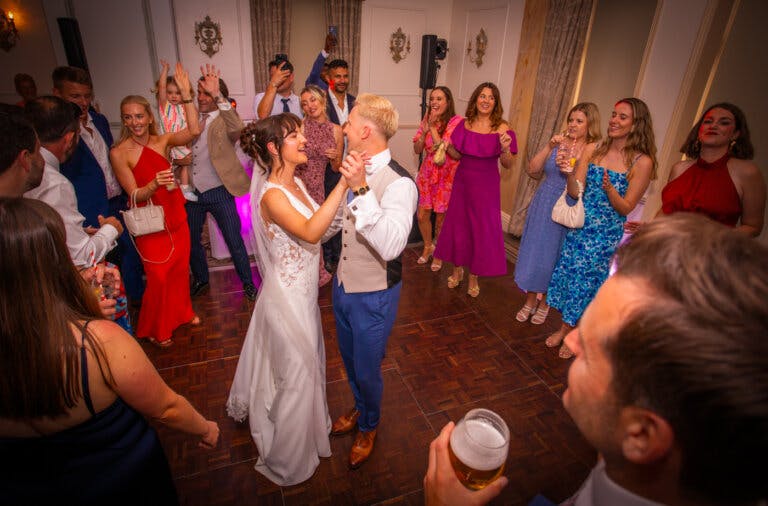 Bride & Groom dancing in the evening surrounded by their friends who are stood in a circle around them