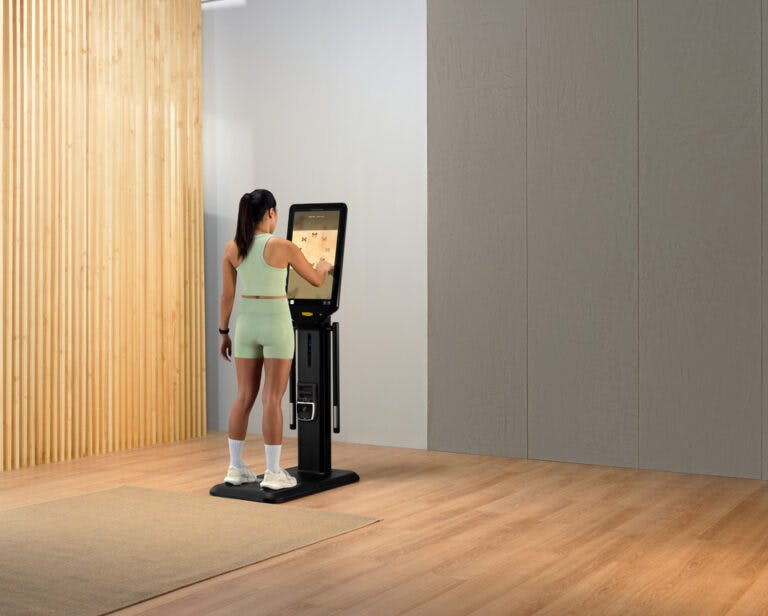 Woman touching screen on Technogym Checkup equipment