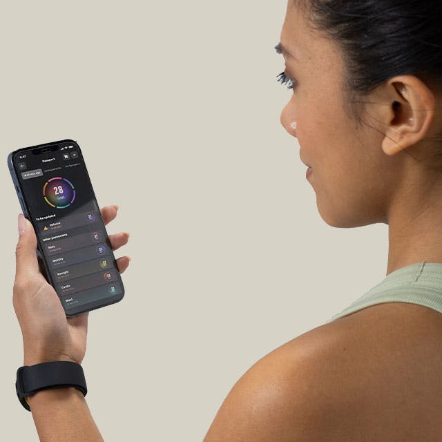 Woman looks at Technogym app on smartphone