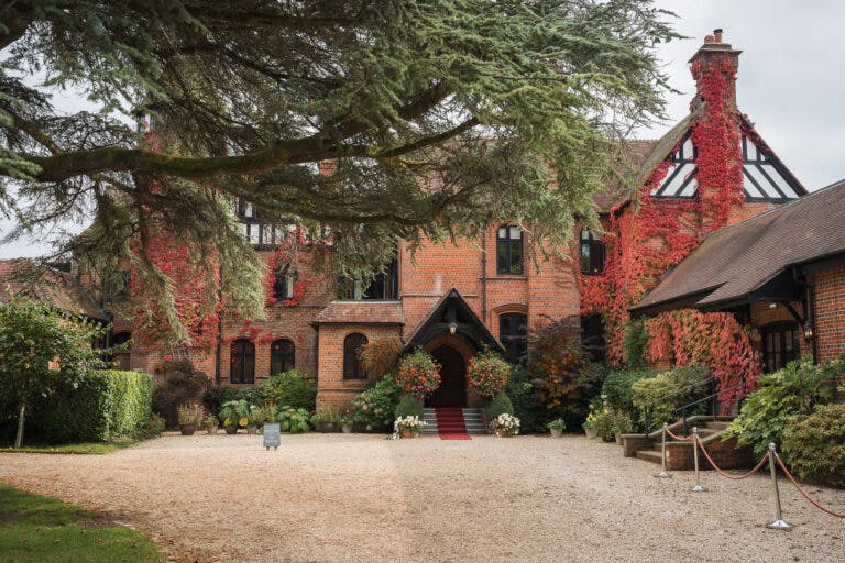 Exterior shot of Careys Manor in autumn showing red ivy growing