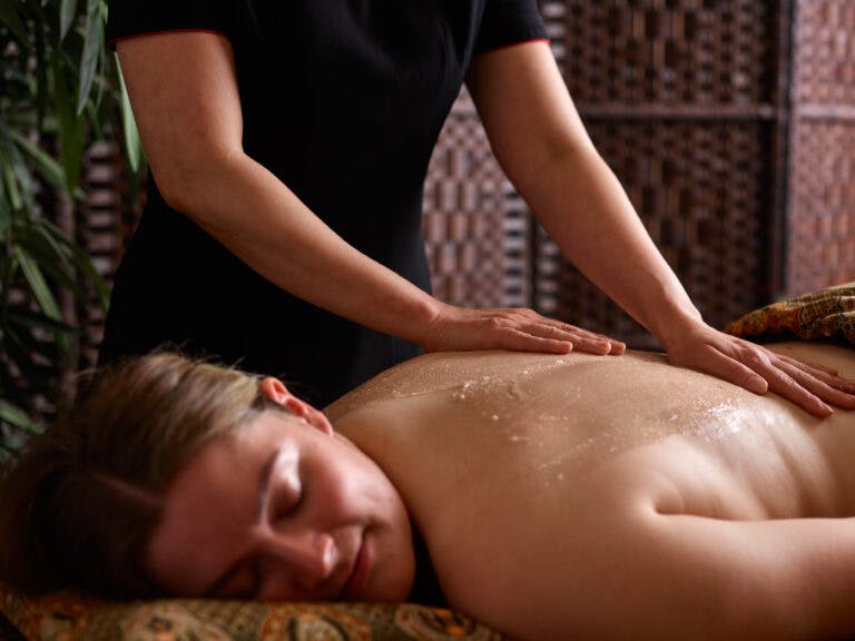 Woman receives body scrub treatment in Thai spa