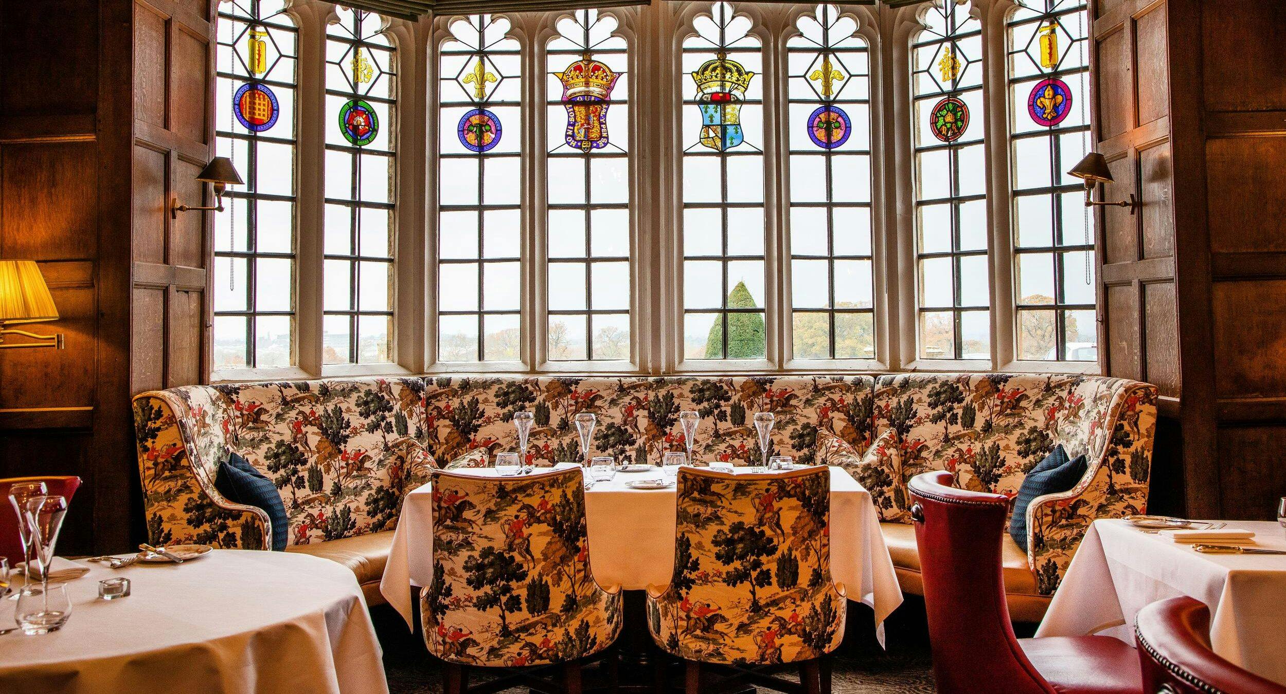 The Restaurant 15th-century wood-panelled dining hall with stone fireplace, chandeliers, and fine dining table settings