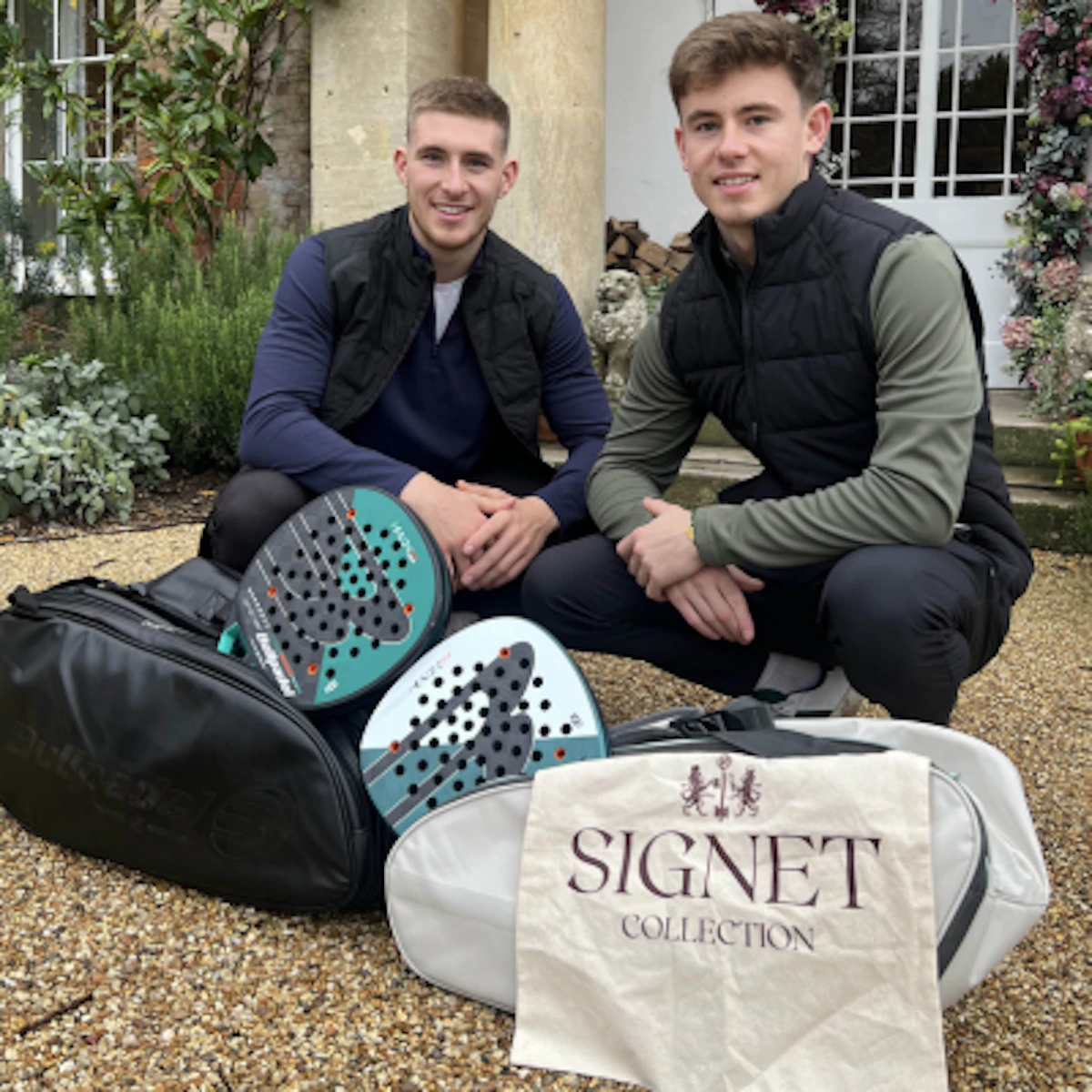 Two players with padel rackets and kit bags outside The Retreat Elcot Park