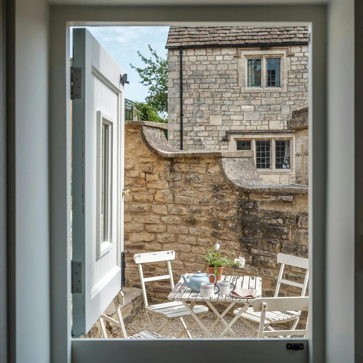 The Cottage private Cotswold stone retreat sitting room with wood-burning fireplace and deep sofas