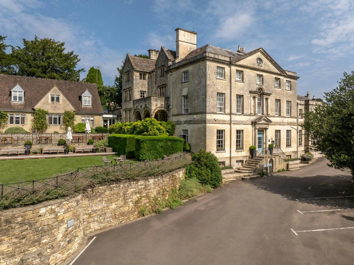 The Painswick 18th-century Palladian stone mansion exterior framed by manicured Cotswold gardens